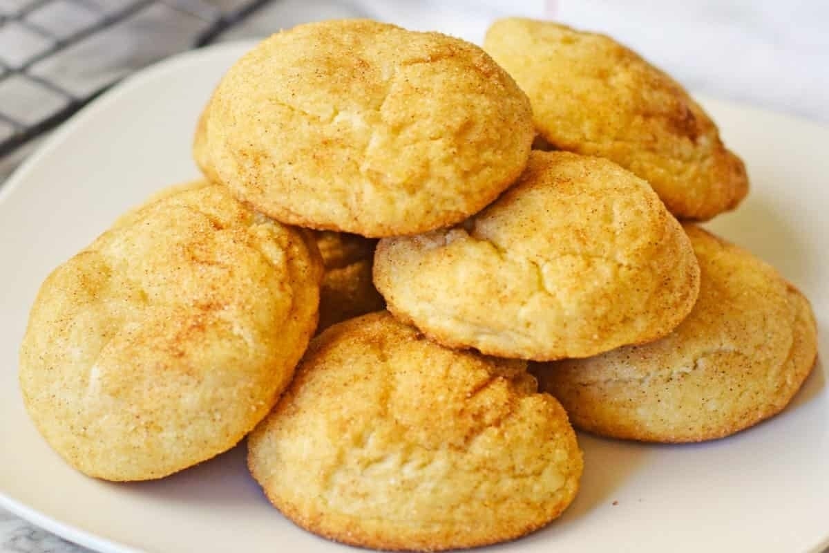 A stack of cinnamon sugar cookies on a white plate, perfect for freezable cookie recipes.