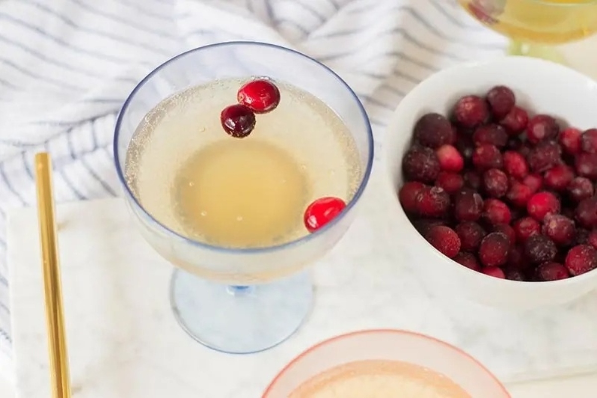 Two glasses of cranberry champagne with cranberries in them, perfect for a sparkling New Year's eve party.