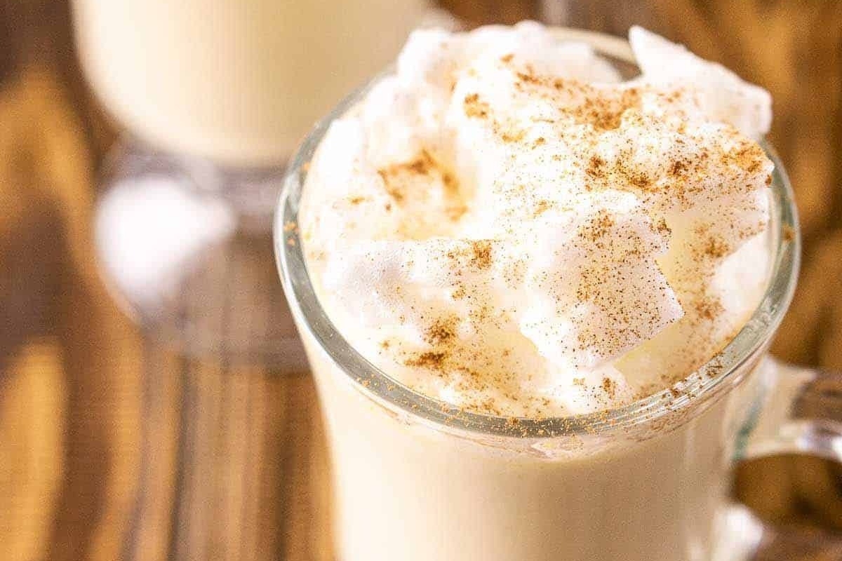Two Christmas cocktails with whipped cream and cinnamon on top.