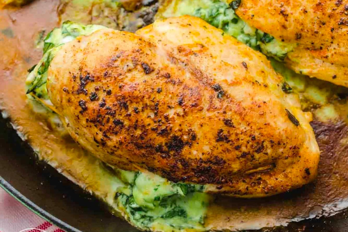 A delicious and hearty New Year's dinner featuring chicken stuffed with spinach cooked in a skillet.