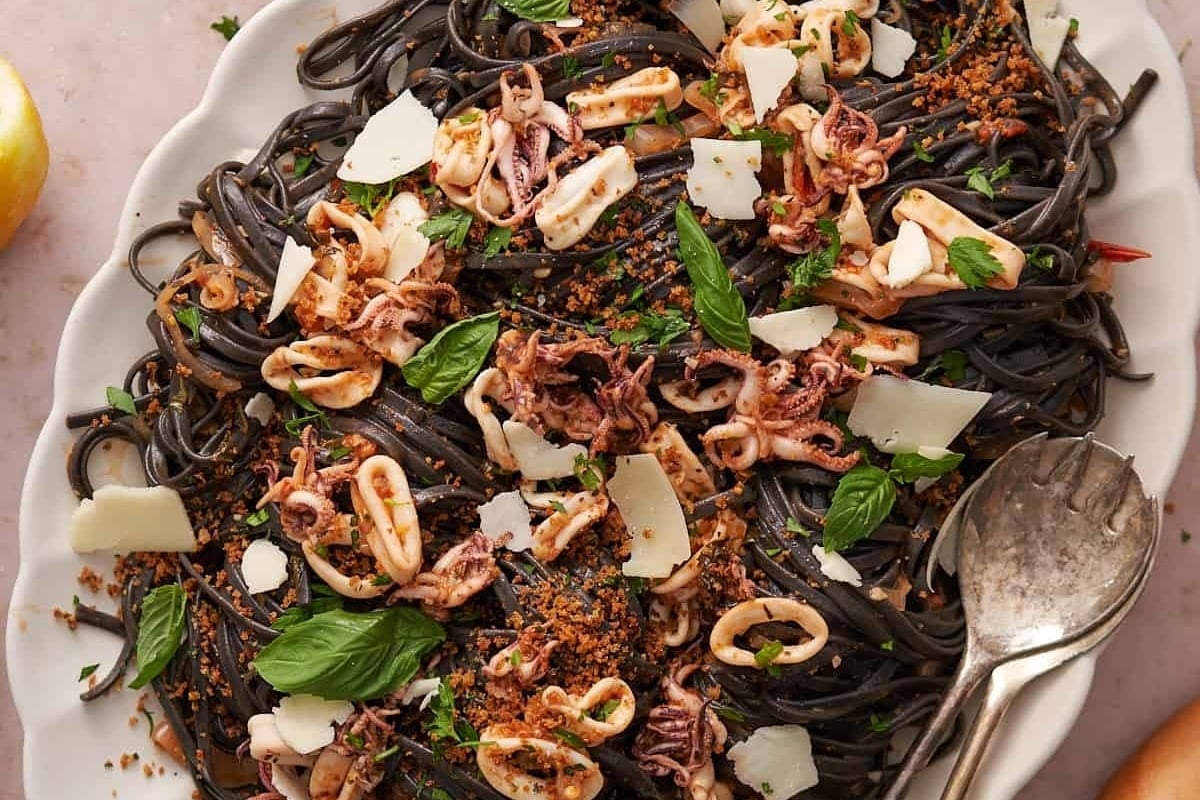 Feast of seven fishes featuring black spaghetti with octopus and parsley.