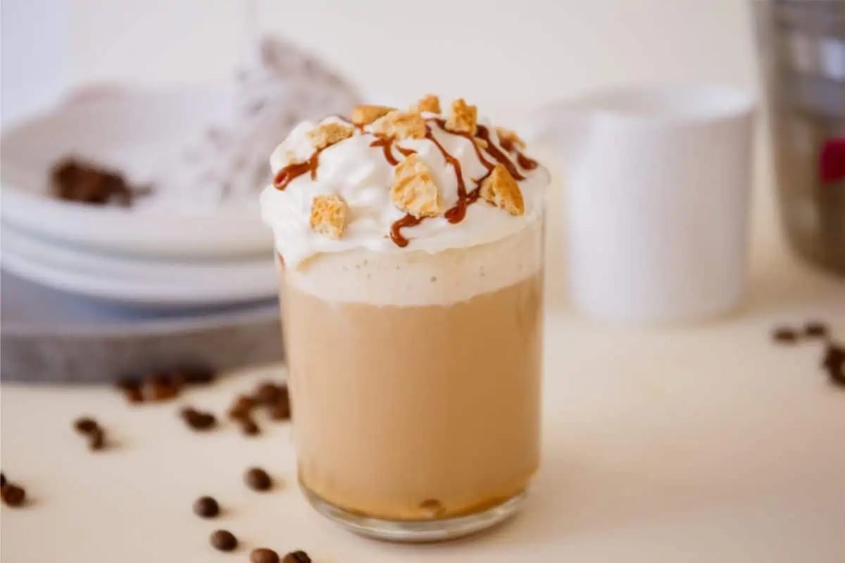 A Starbucks holiday latte with whipped cream and coffee beans.