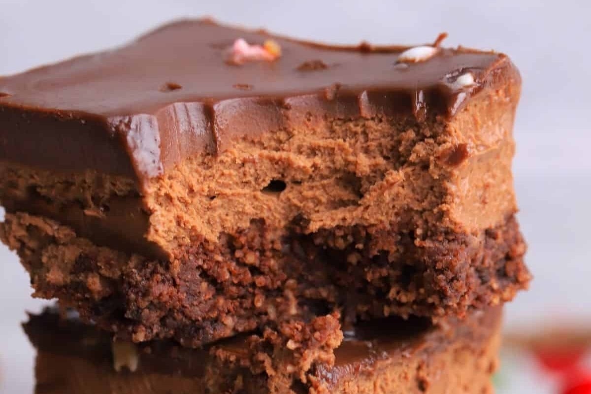 A stack of chocolate brownies on a white plate, perfect for peppermint lovers.