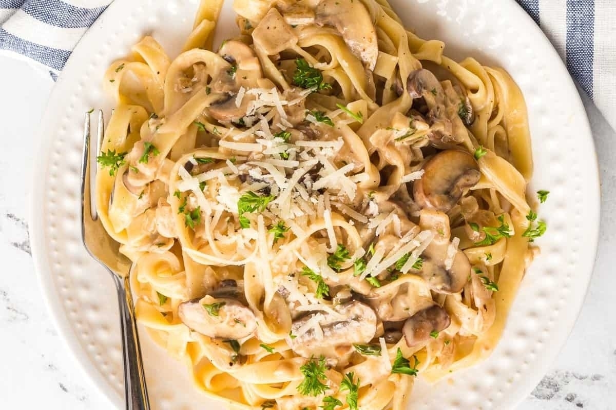 New Year's Eve meal idea: Mushroom fettuccine served elegantly on a white plate with a fork.