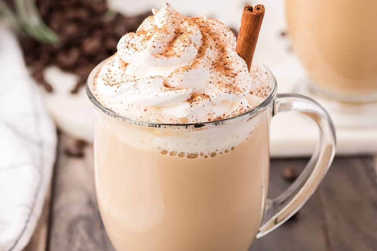 A delicious coffee latte with a touch of cinnamon and a dollop of whipped cream.