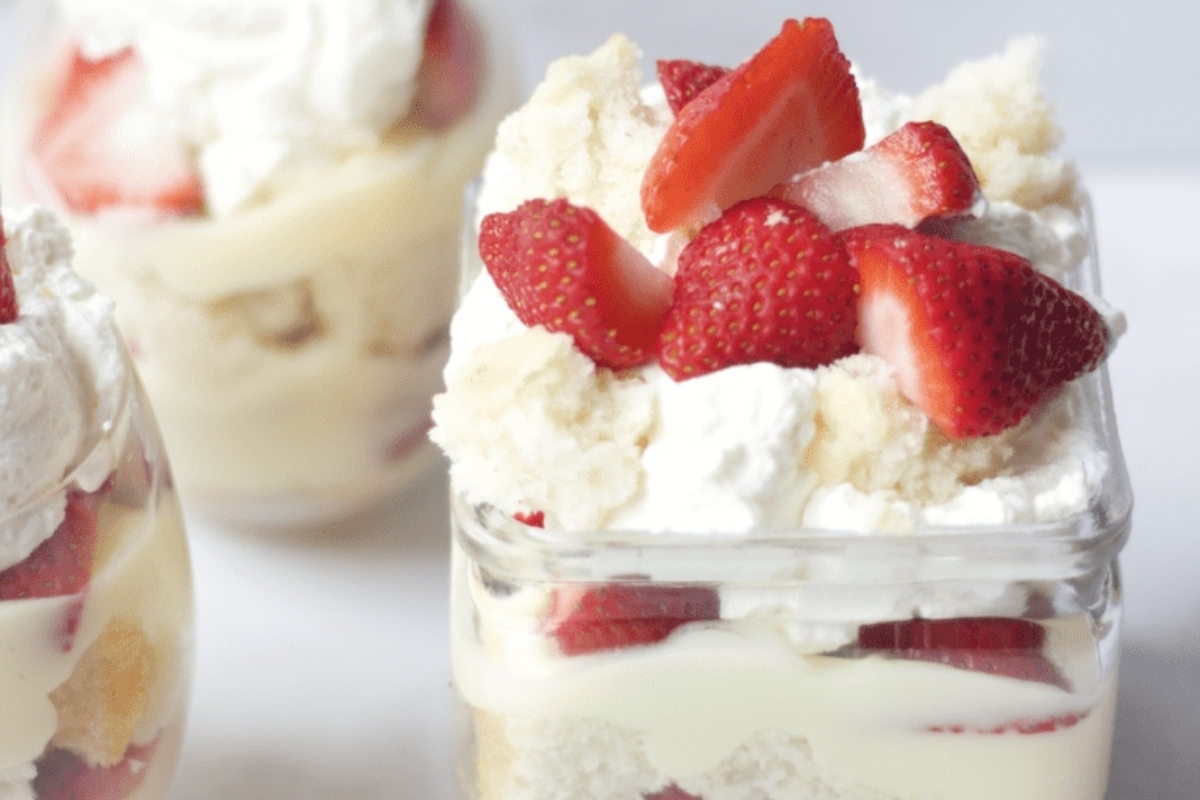 Christmas strawberry trifle in a jar with whipped cream and strawberries.