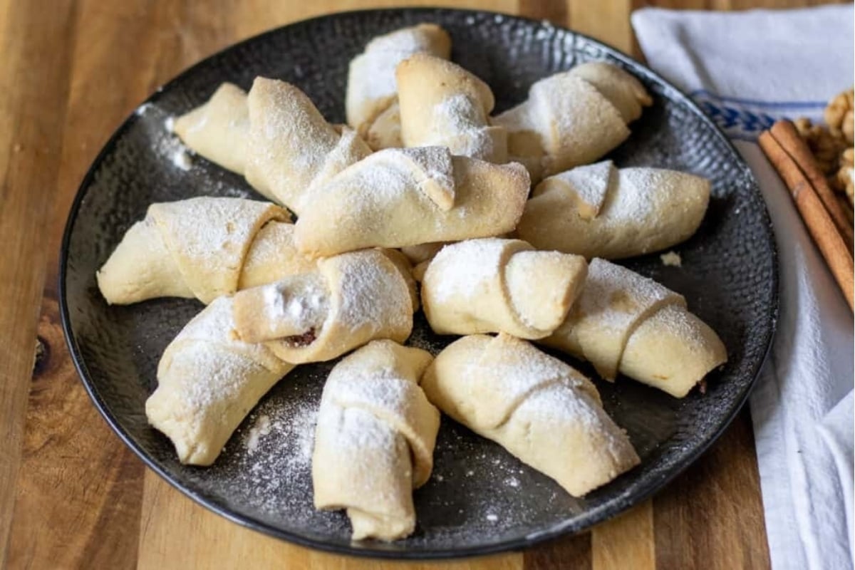 A plate with cinnamon and powdered sugar filled pastries - ideal for freezable cookie recipes.
