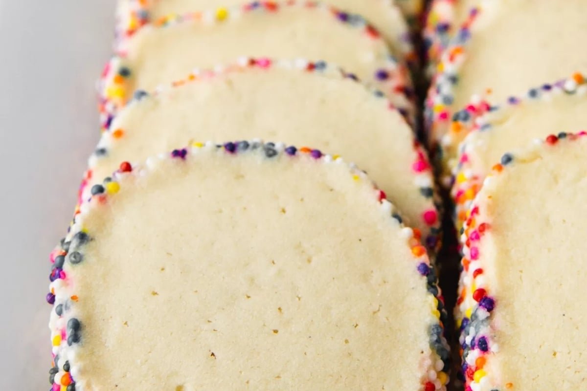 Easy-to-make sugar cookies with colorful sprinkles on a white plate.