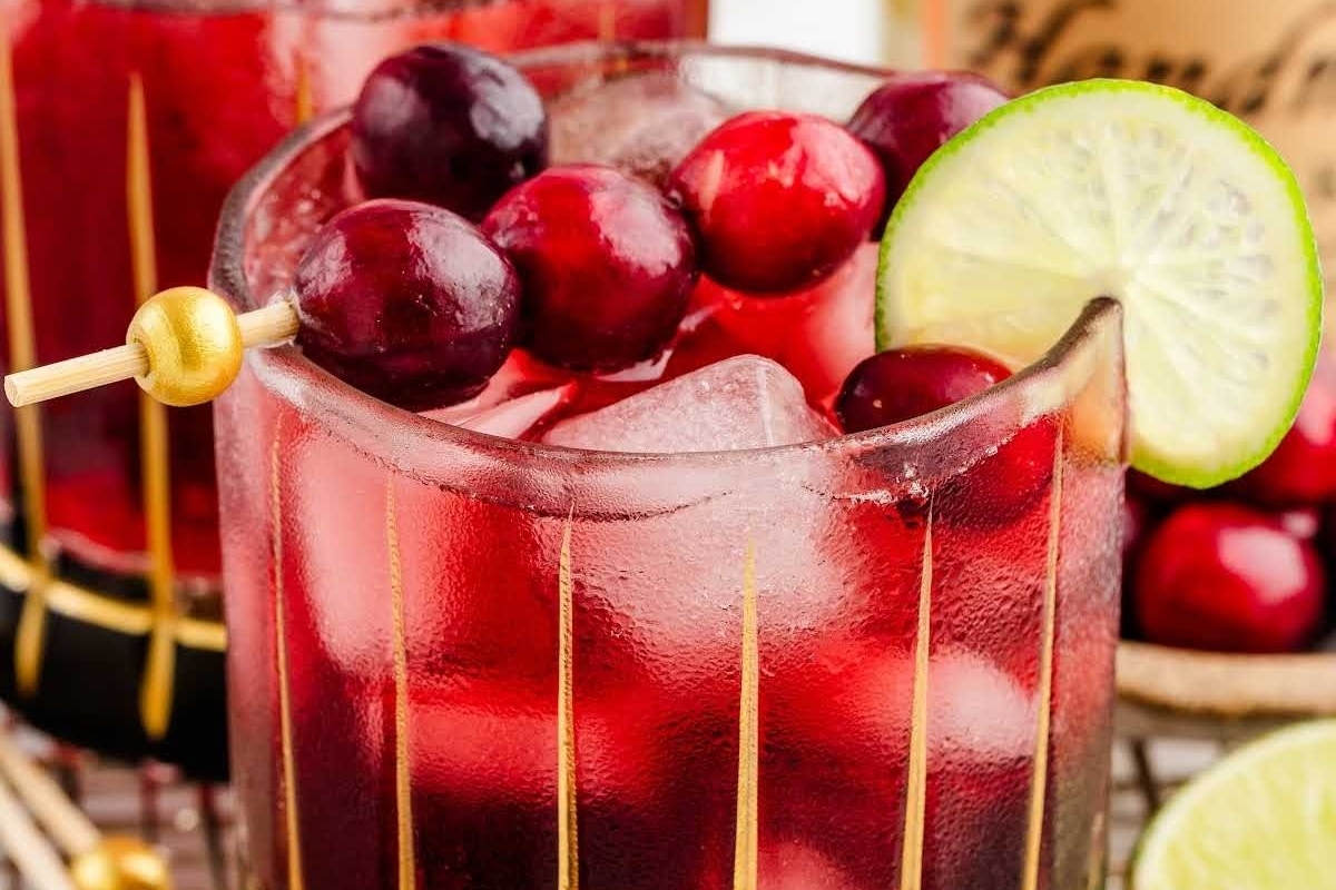 Festive cranberry margarita with lime and lime wedges, perfect for Christmas cocktails.