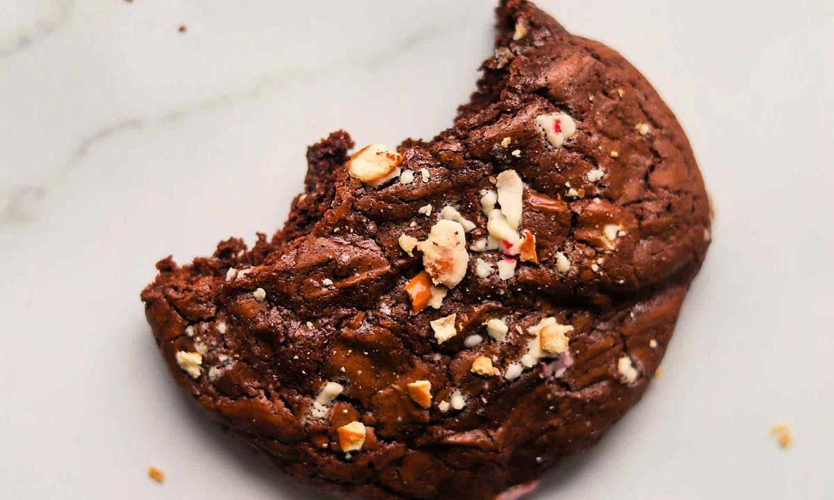 A crinkle cookie with a bite taken out of it.