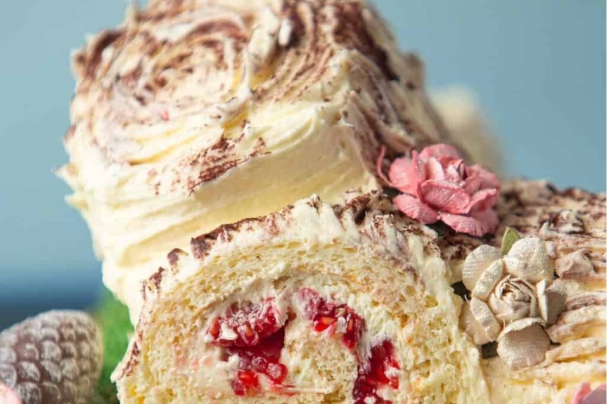 A Christmas cake with cream and cherries on top.