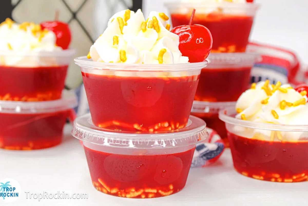 A group of plastic cups filled with jello shots.