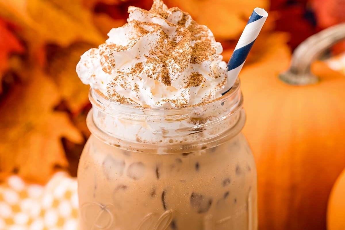 A Starbucks pumpkin spice latte in a mason jar with whipped cream.