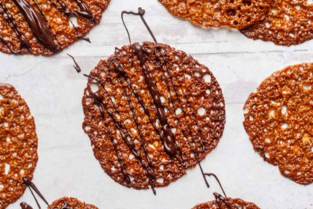 A plate of chocolate dipped cookies on a white surface.