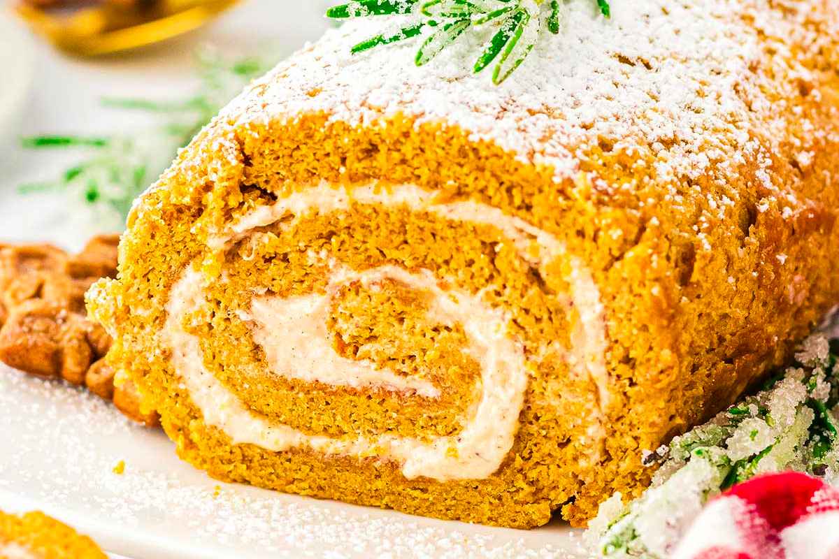 A pumpkin roll is sitting on a white plate.