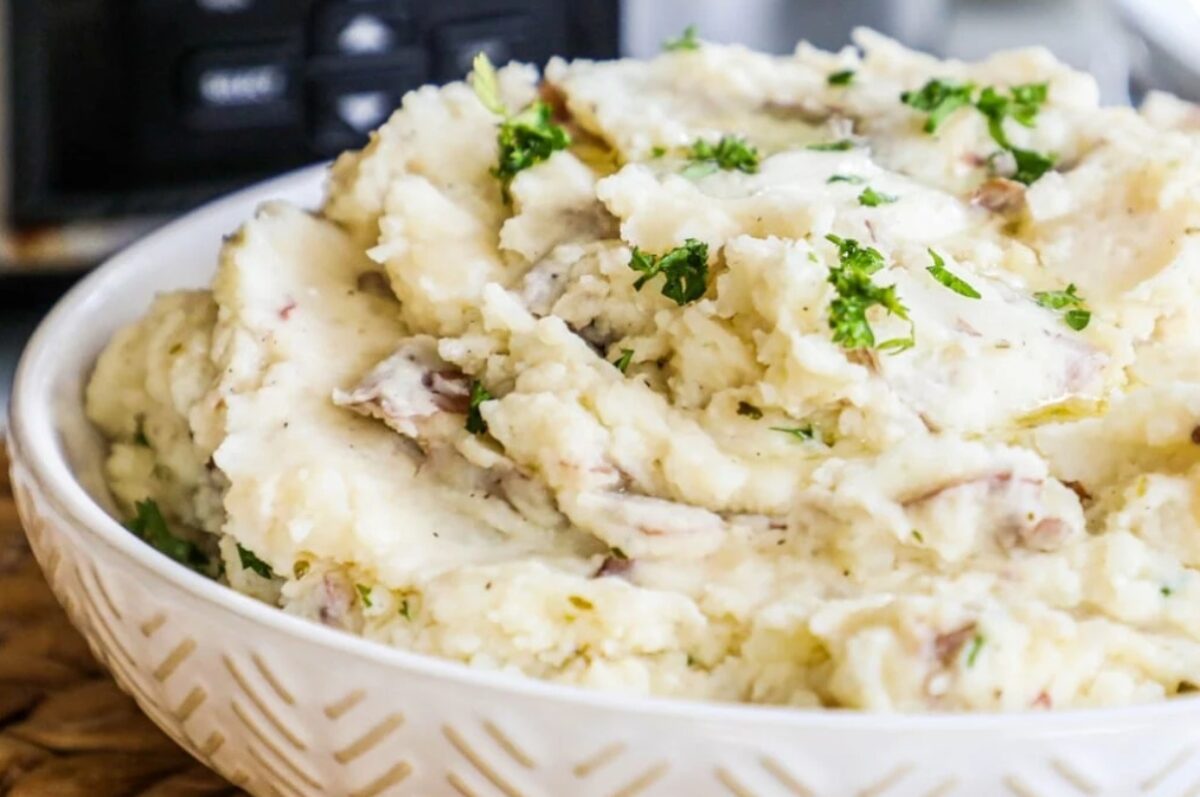 Make-ahead mashed potatoes in a bowl with parsley, perfect for holiday dishes.