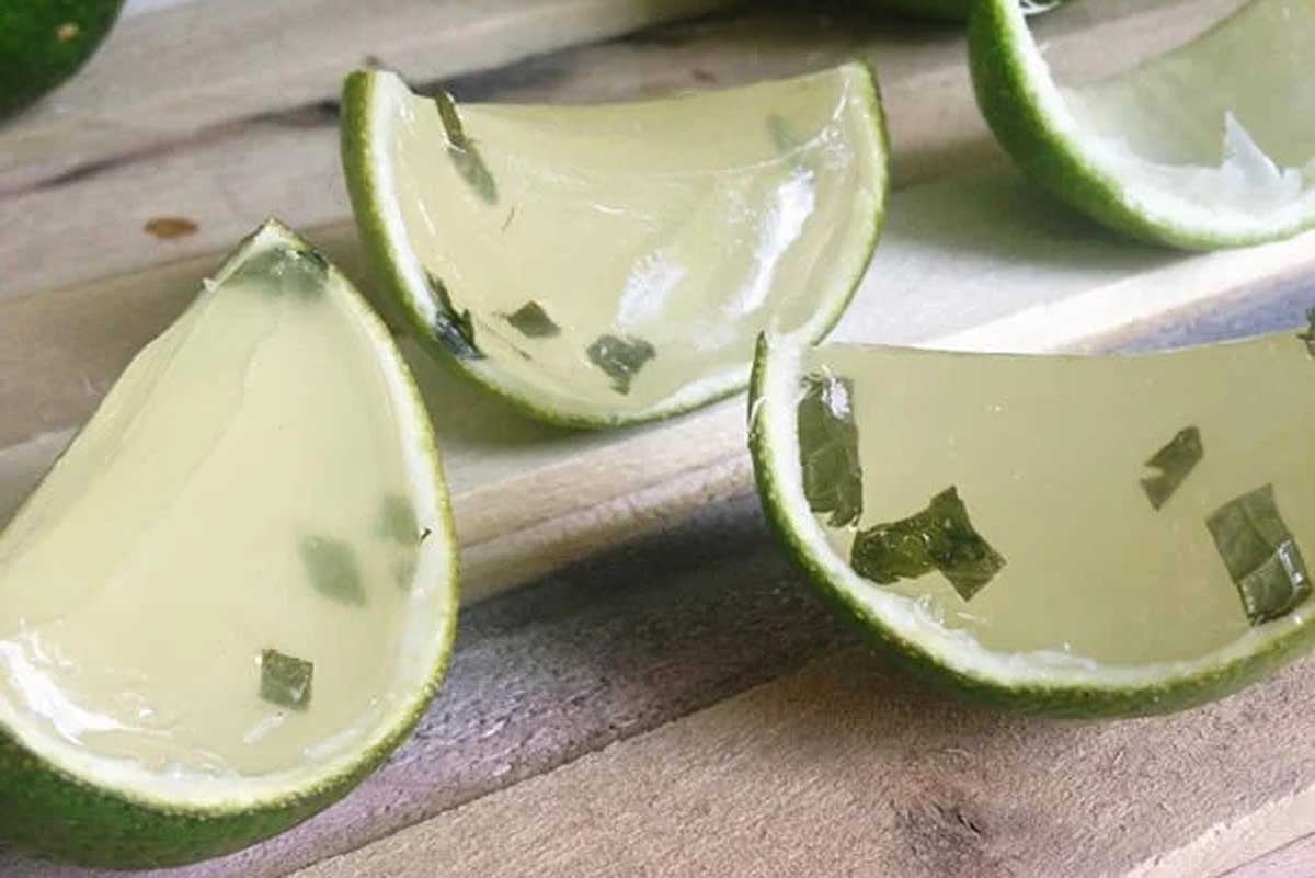 A slice of lime sitting on top of a cutting board, perfect for enhancing jello shots.