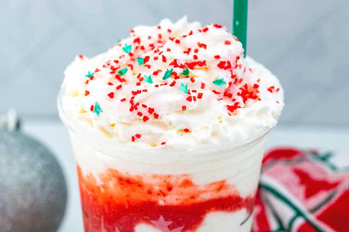 A delightful Starbucks holiday drink adorned with whipped cream and sprinkles.