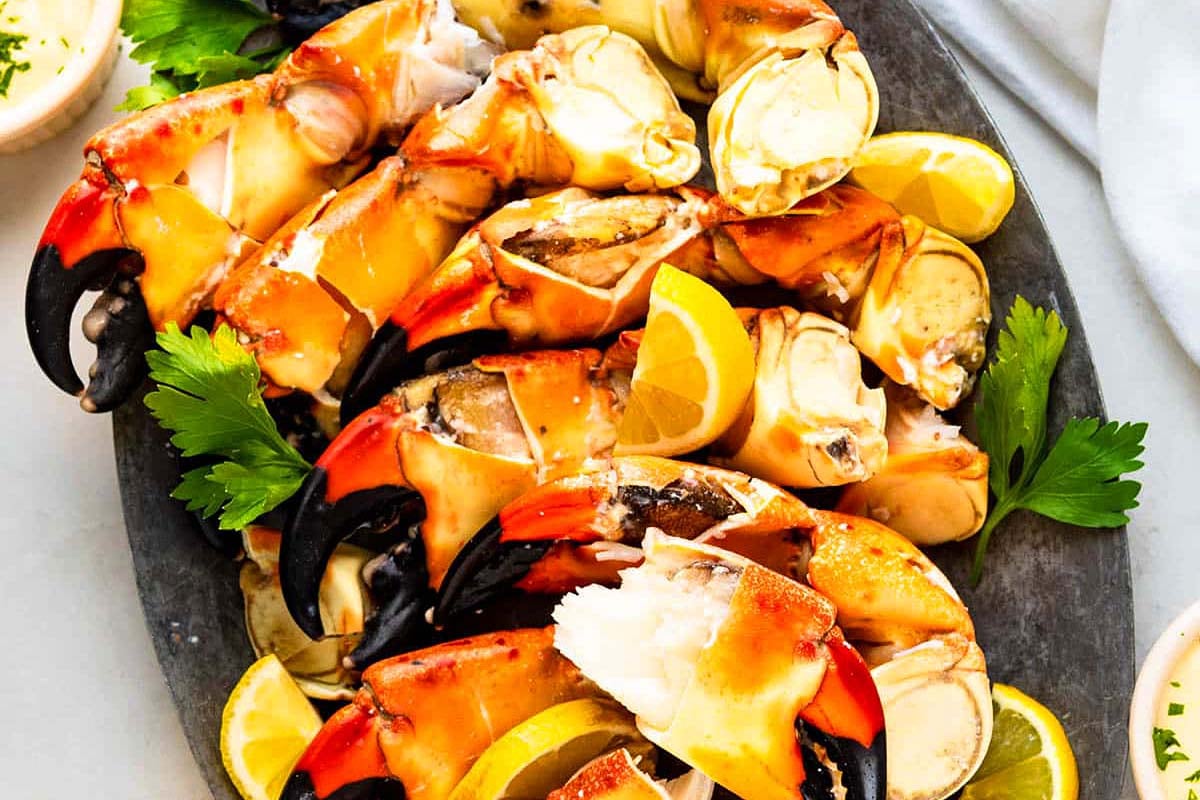 Crab claws on a platter with lemon wedges and parsley, perfect for a feast of seven fishes.