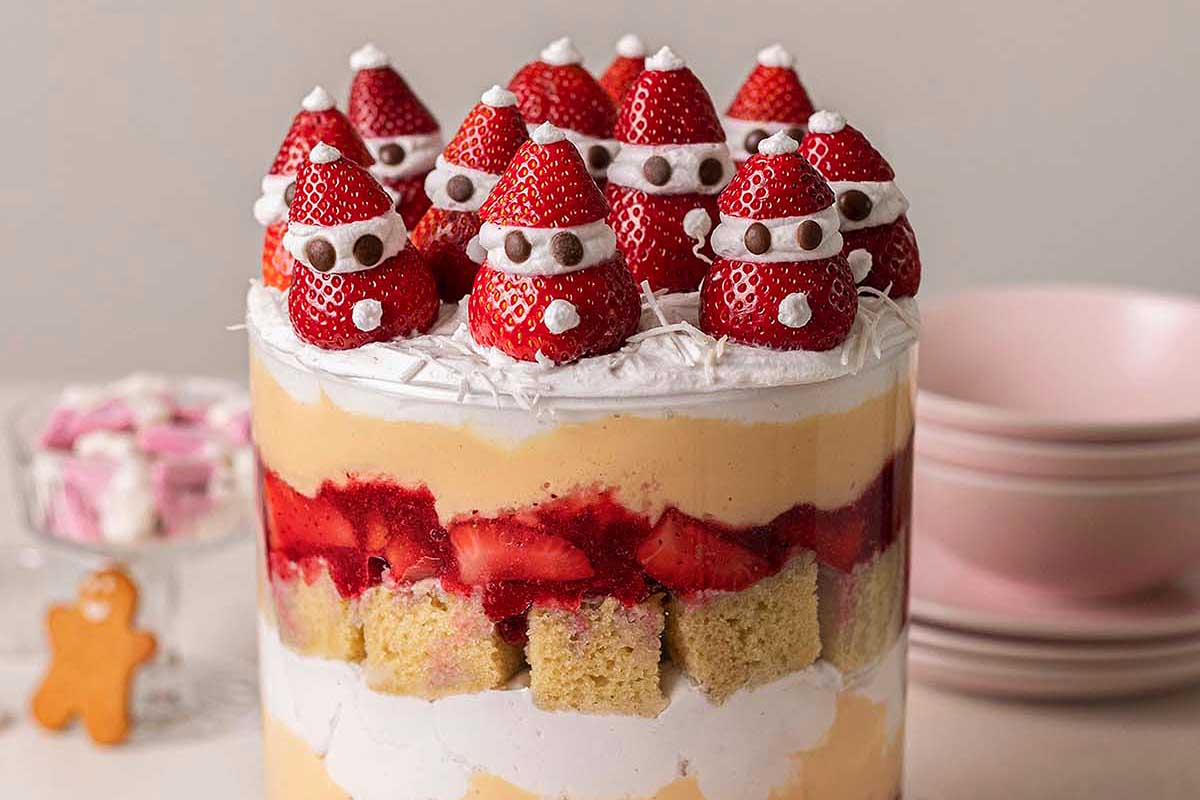 A festive Christmas trifle adorned with a jolly Santa Claus figurine on top.
