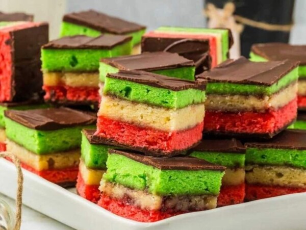 A plate of green, red, and white cookies on a white plate.