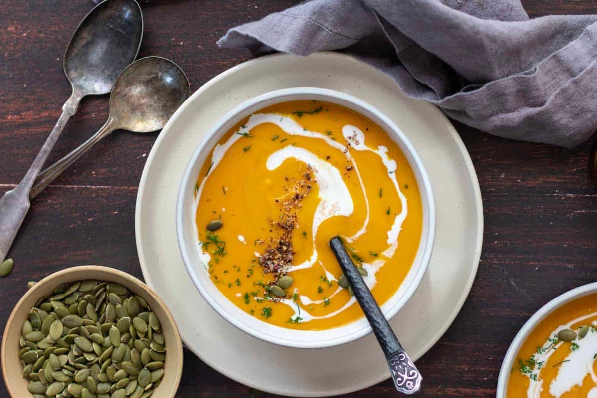 Creamy pumpkin soup on a wooden table.