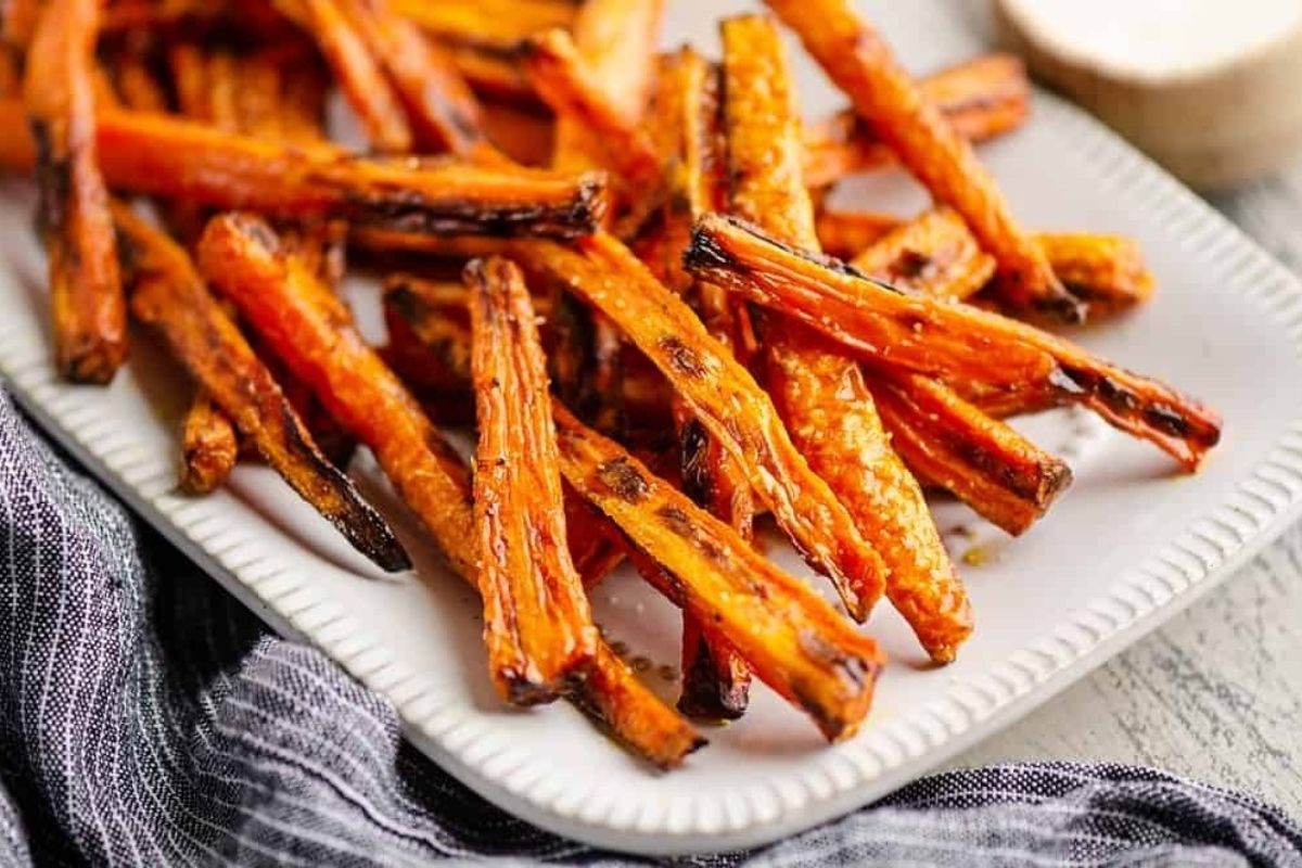 Roasted wholesome sweet potato fries on a white plate.