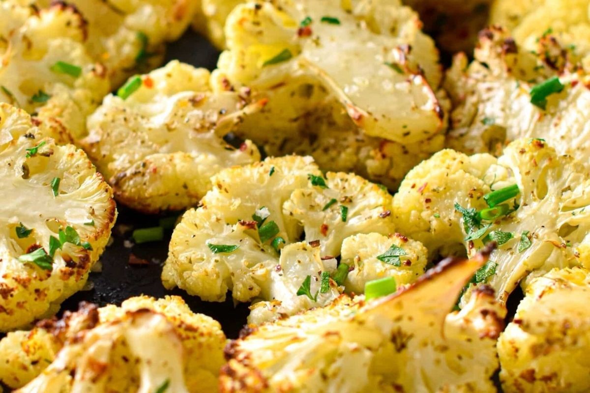Wholesome roasted cauliflower with chives on a baking sheet.