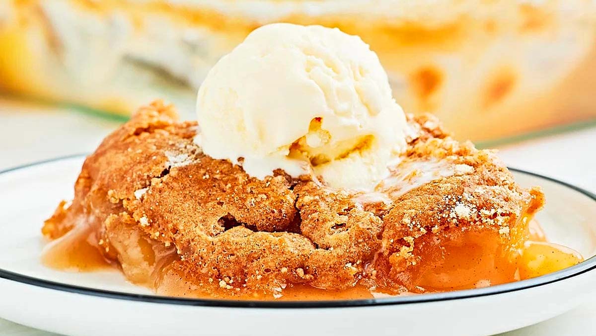 A plate of apple cobbler with ice cream and dump cakes on top.