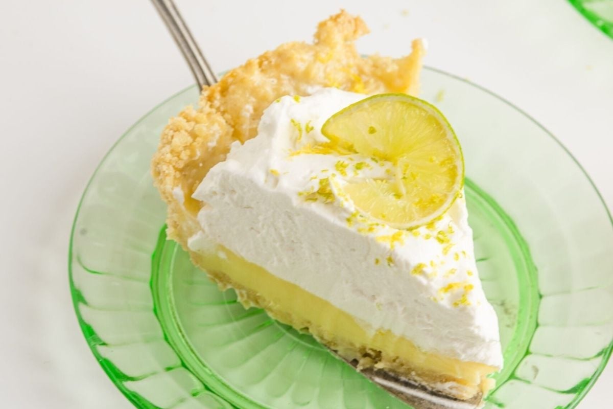 A slice of lime pie on a green plate, perfect for citrus lovers.