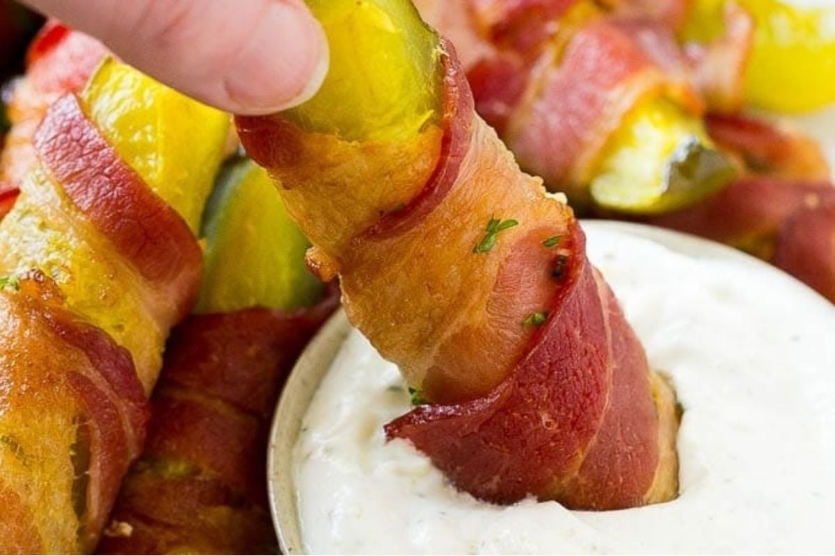 A tantalizing platter of bacon-wrapped pickles served with a delectable dipping sauce, perfect for those seeking unique and mouthwatering pickle recipes.
