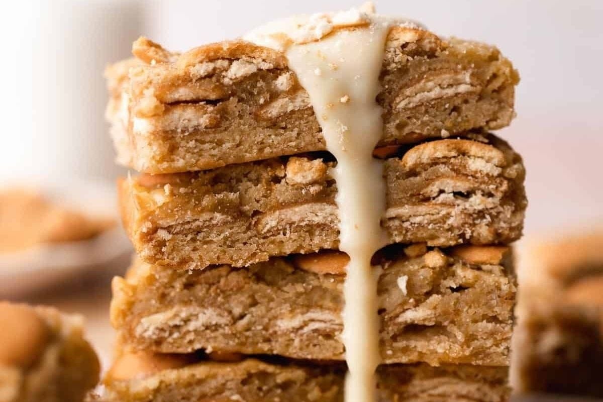 A stack of peanut butter cookie bars with a drizzle of icing, perfect for brownie recipes.