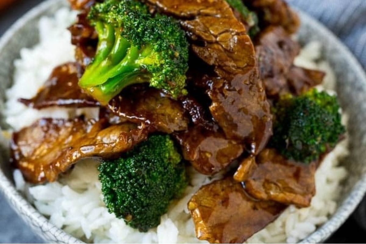 Beef and broccoli in a savory sauce served over a bed of white rice in a bowl—a classic dish often enjoyed among favorite Lunar New Year recipes.