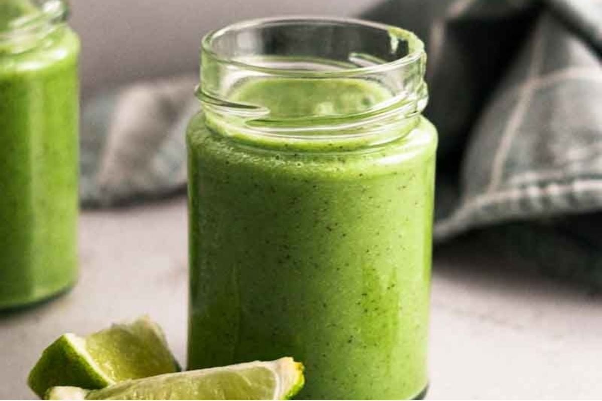 A green smoothie in a jar with lime slices, featuring pinwheel recipes.