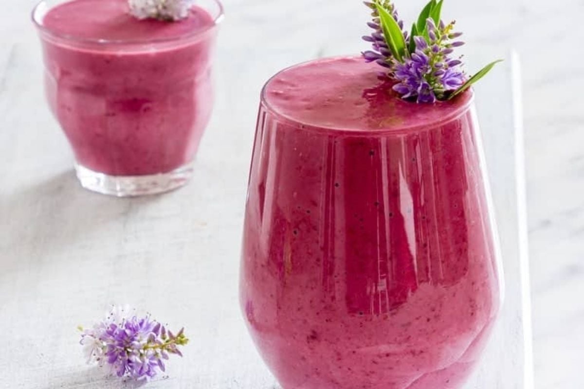 A purple smoothie with pinwheel lavender flowers on top.