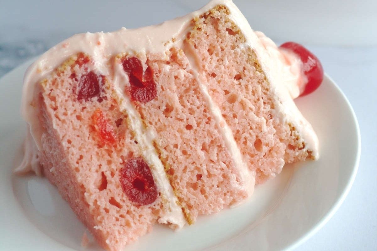 A slice of pink cake on a white plate, perfect for those who love indulging in delightful and visually appealing pink recipes.