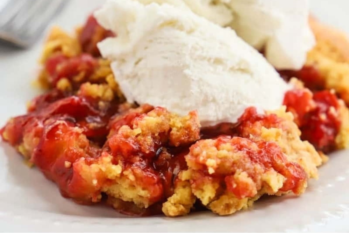 Delicious strawberry cobbler served with a scoop of ice cream on a plate.