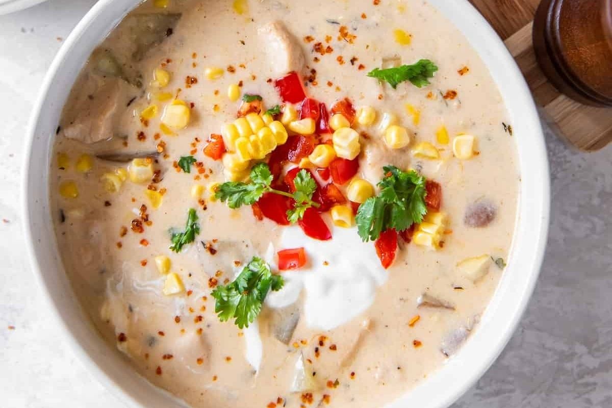 Delicious chicken corn chowder served in a white bowl.
