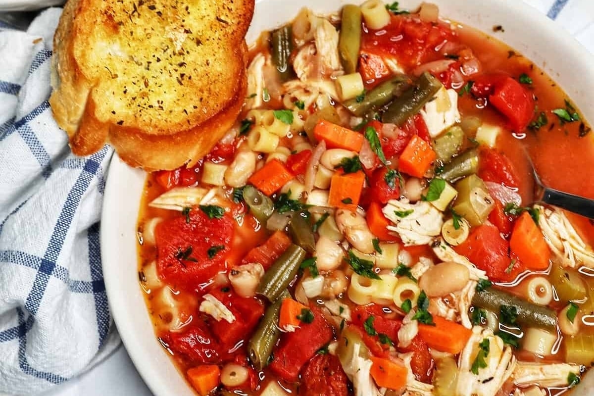 Chicken noodle soup, a classic dish made from tender chicken and noodles, served in a comforting white bowl. Pair it with some crusty bread for the ultimate comfort meal experience.