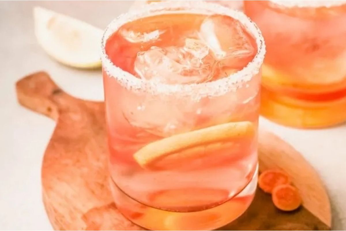 Two glasses of pink margarita on a wooden cutting board perfect for citrus recipes.