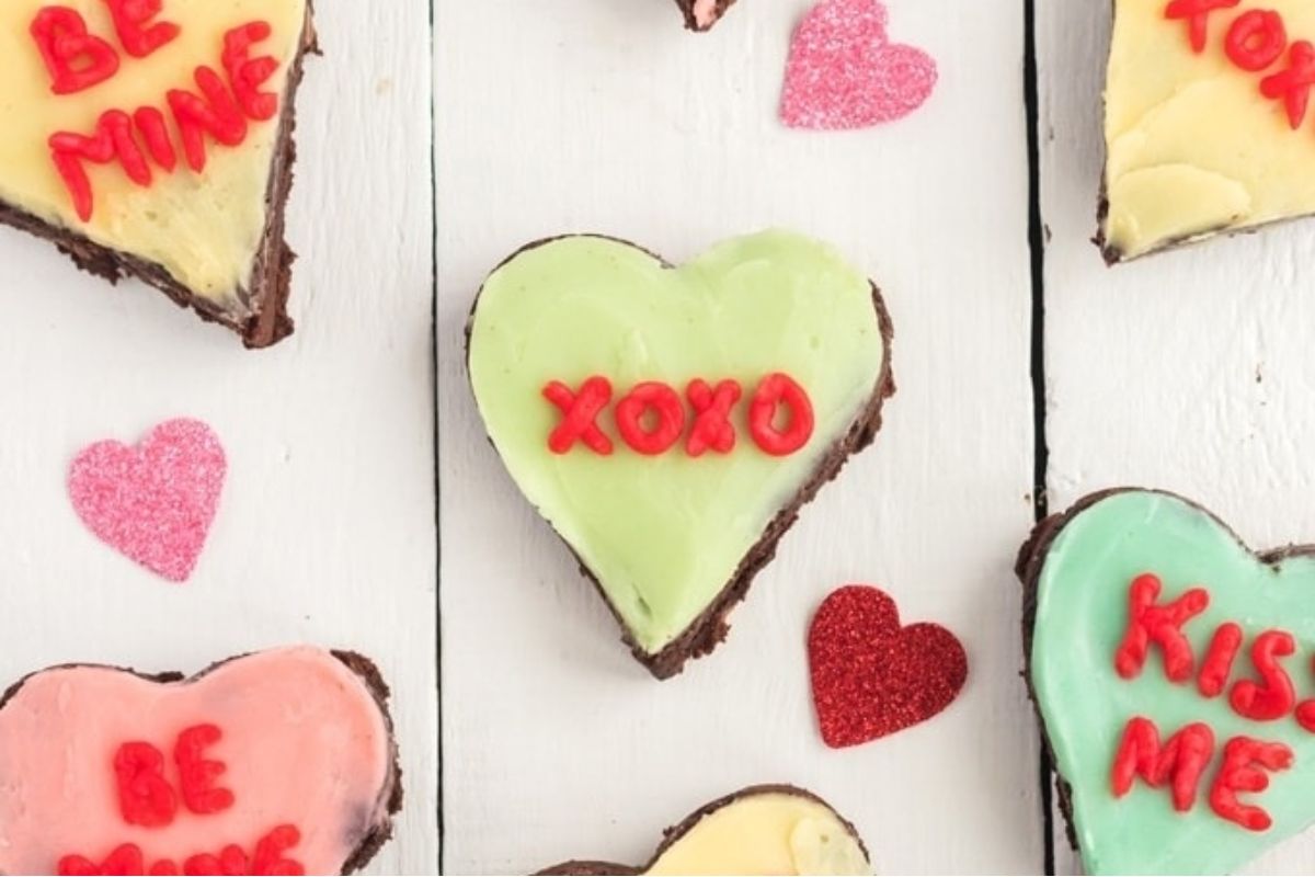Heart shaped cookies with frosting and red text, perfect for Valentine's Day or any occasion to express your love. These heart-shaped treats are delicately crafted to make a sweet impression. The creamy frosting adds