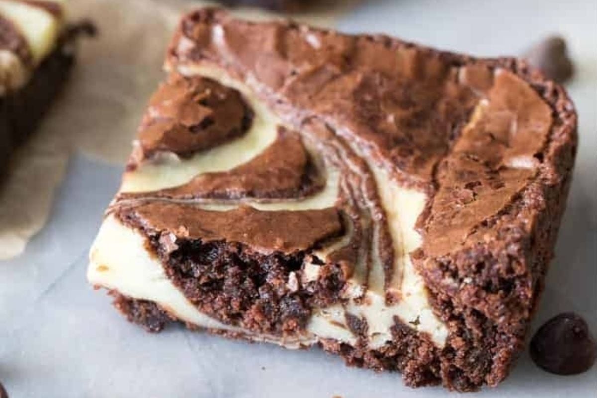 A tantalizing slice of chocolate brownie with a delectable swirl on top.