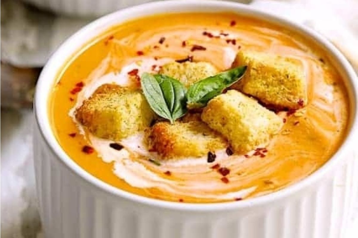 A delicious tomato soup, garnished with crispy croutons and fragrant basil.