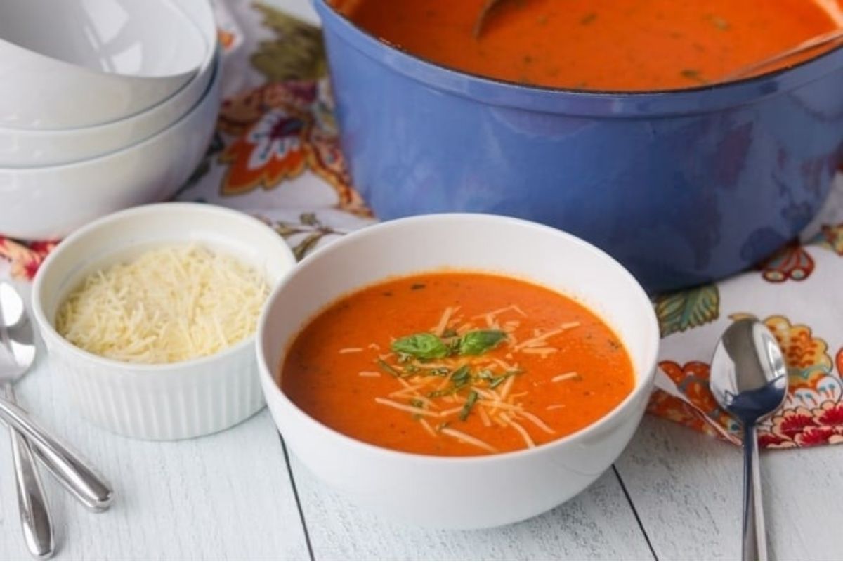 A delicious bowl of tomato-based soup topped with generous grated Parmesan.