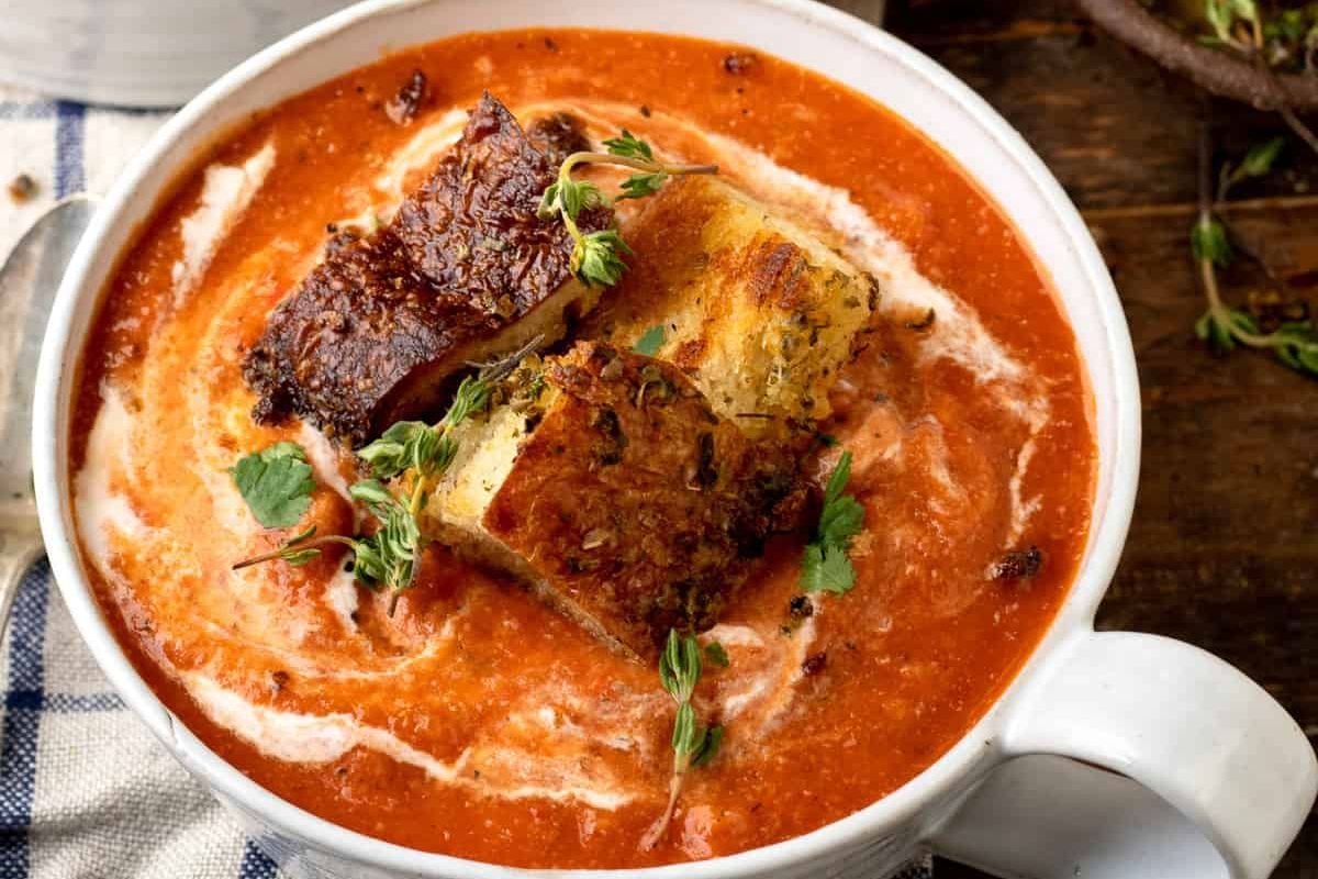 A bowl of tomato soup with tofu, perfect for those who love tomato-based soup recipes.