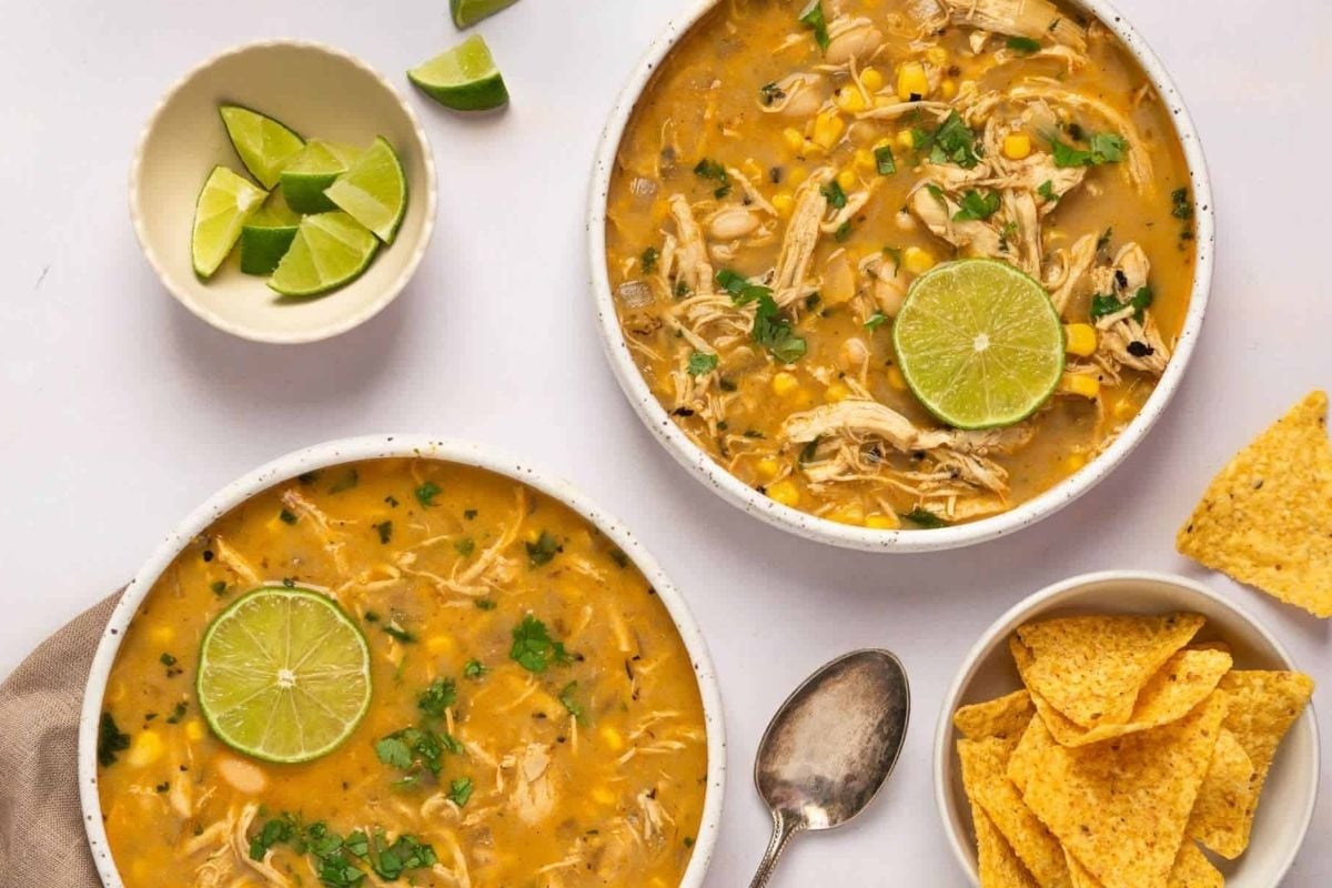 Wholesome Mexican chicken soup with tortilla chips, cooked in a slow cooker.