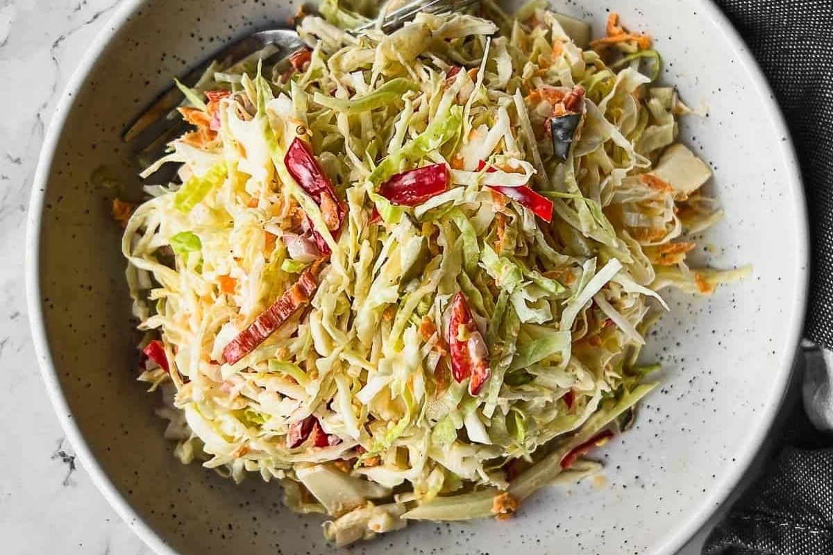 Tangy coleslaw in a bowl, perfect for enjoying with a fork.