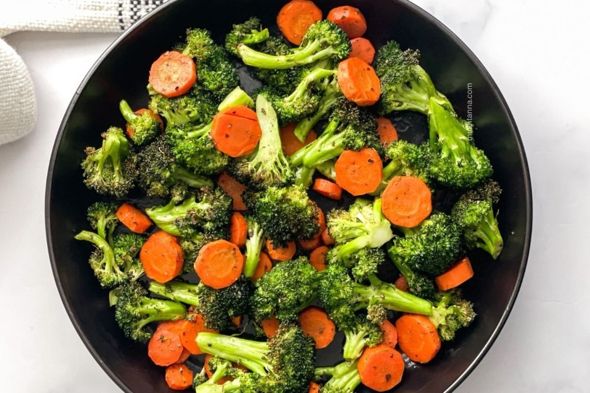 Wholesome broccoli and carrot medley in a black bowl.