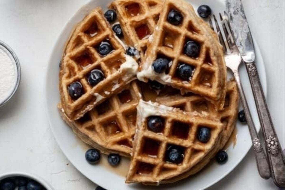         Waffles with blueberries and cream on a plate, served using an exquisite waffle recipe.