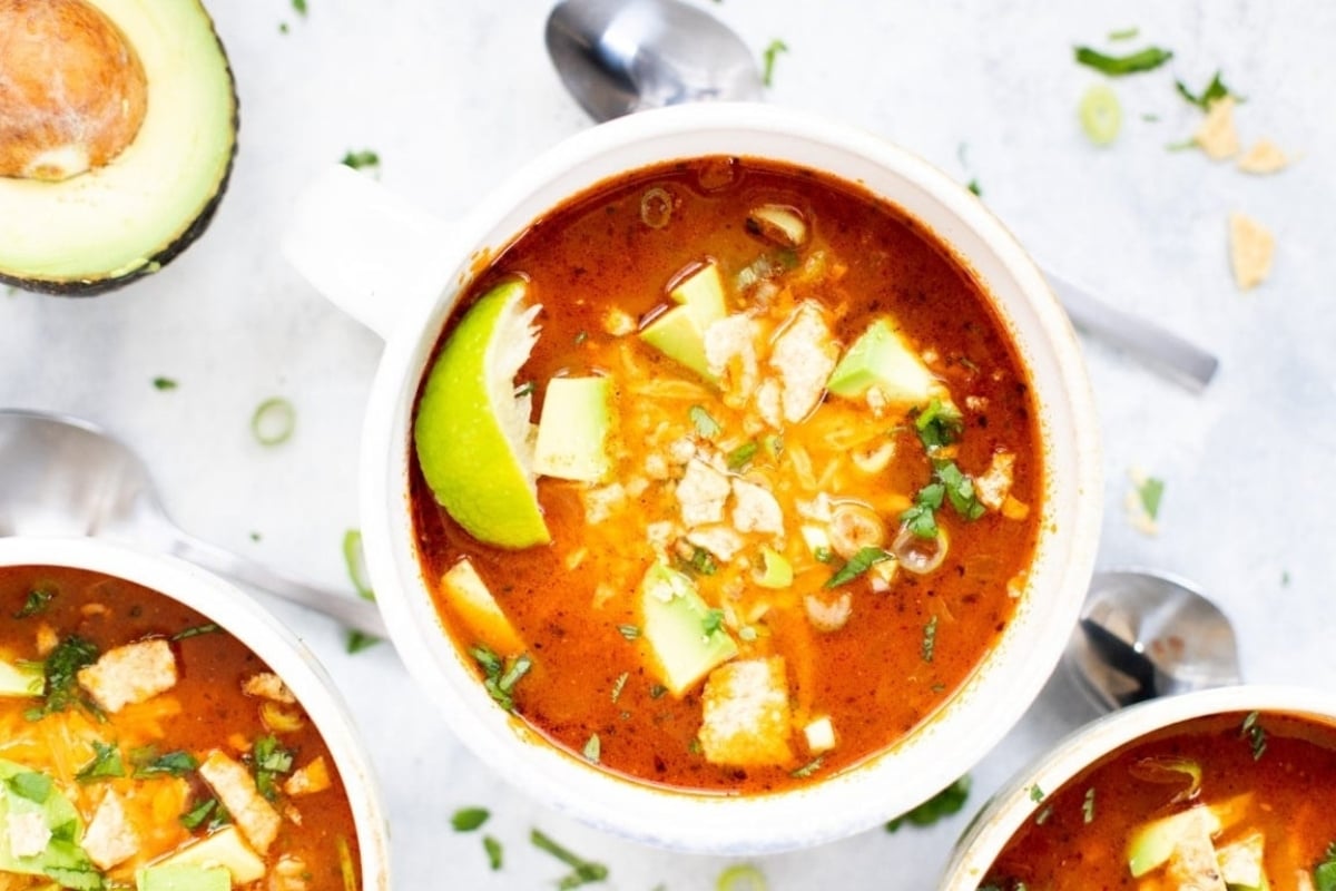 A bowl of delicious mexican chicken soup topped with creamy avocado.
